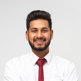 portrait of young indian top manager in t shirt and tie crossed arms and smiling on white isolated background